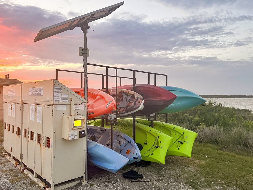 Paddleboard stacked at a rental station.