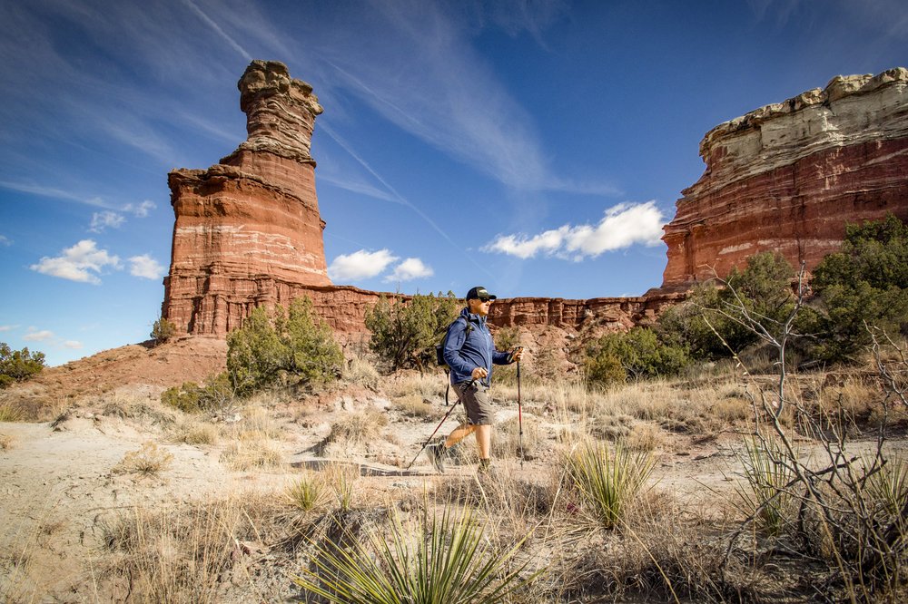 A person hiking in front of Canyon Walls.