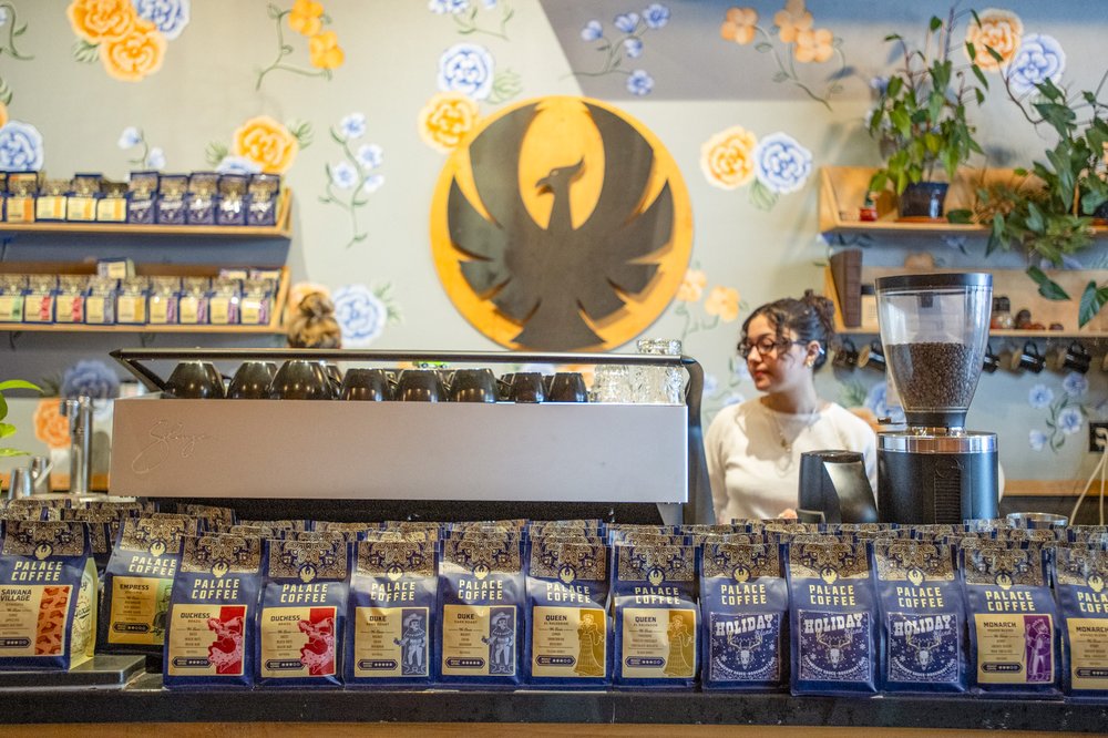 A person standing behind a counter at a coffee shop.