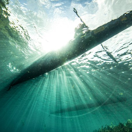 Shot of single paddler racing canoe from underwater on San Marcos River during Texas Water Safari