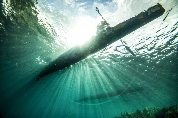 Shot of single paddler racing canoe from underwater on San Marcos River during Texas Water Safari