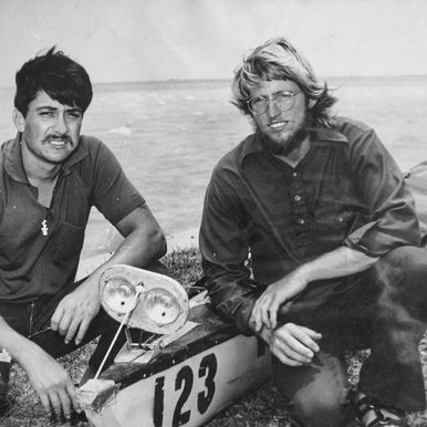 Archived black and white photo of two paddlers next to their racing canoe in 1971