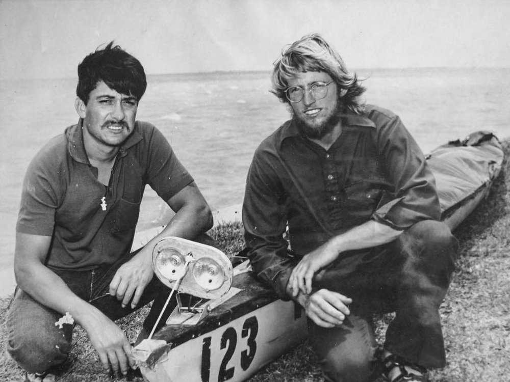 Archived black and white photo of two paddlers next to their racing canoe in 1971
