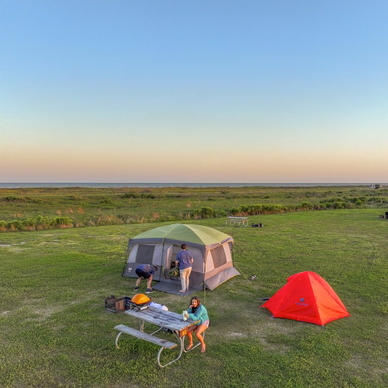 A campsite with two tents and a picnic table at sunset