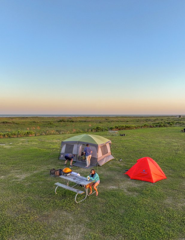 A campsite with two tents and a picnic table at sunset