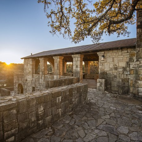 CCC Pavillion next to lake with sun setting behind it
