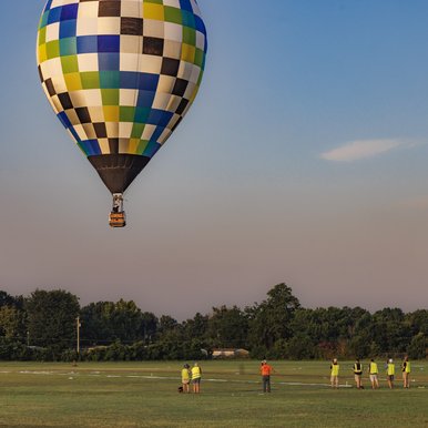 Hot air balloon tossing out bean bag on target for Great Texas Balloon Race in Longview Texas at sunrise