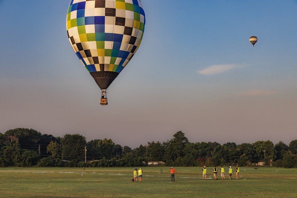 Hot air balloon tossing out bean bag on target for Great Texas Balloon Race in Longview Texas at sunrise