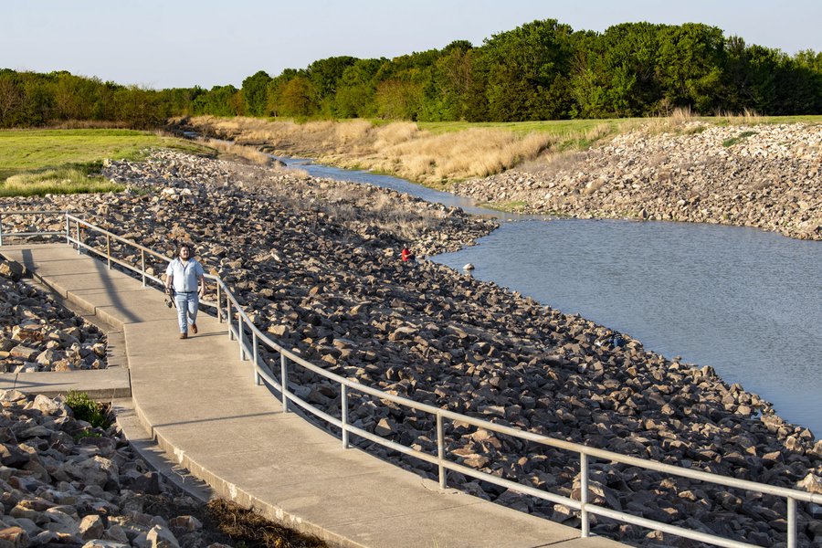 A person walking a trail along a river.