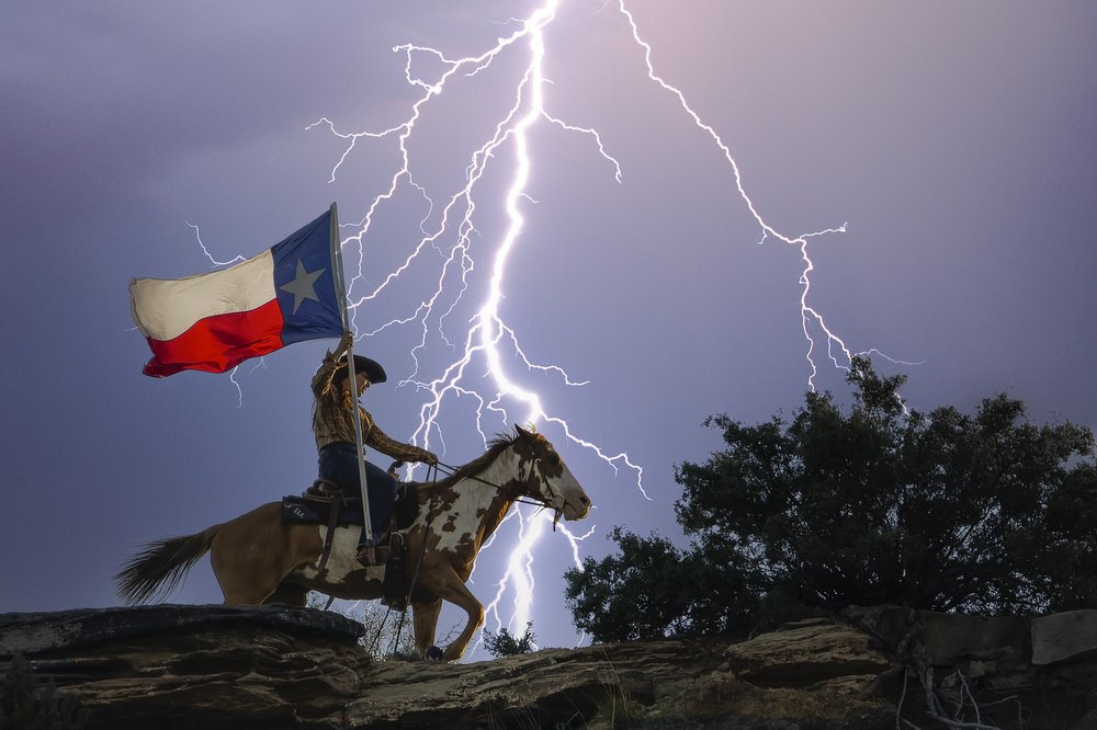 Person on horseback with a Texas flag with a large lightning bolt in the background