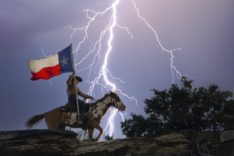 Person on horseback with a Texas flag with a large lightning bolt in the background