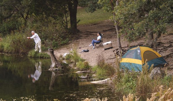 An overhead view of a tent and and a person in a camping chair.