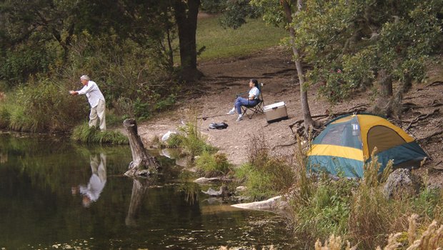 An overhead view of a tent and and a person in a camping chair.