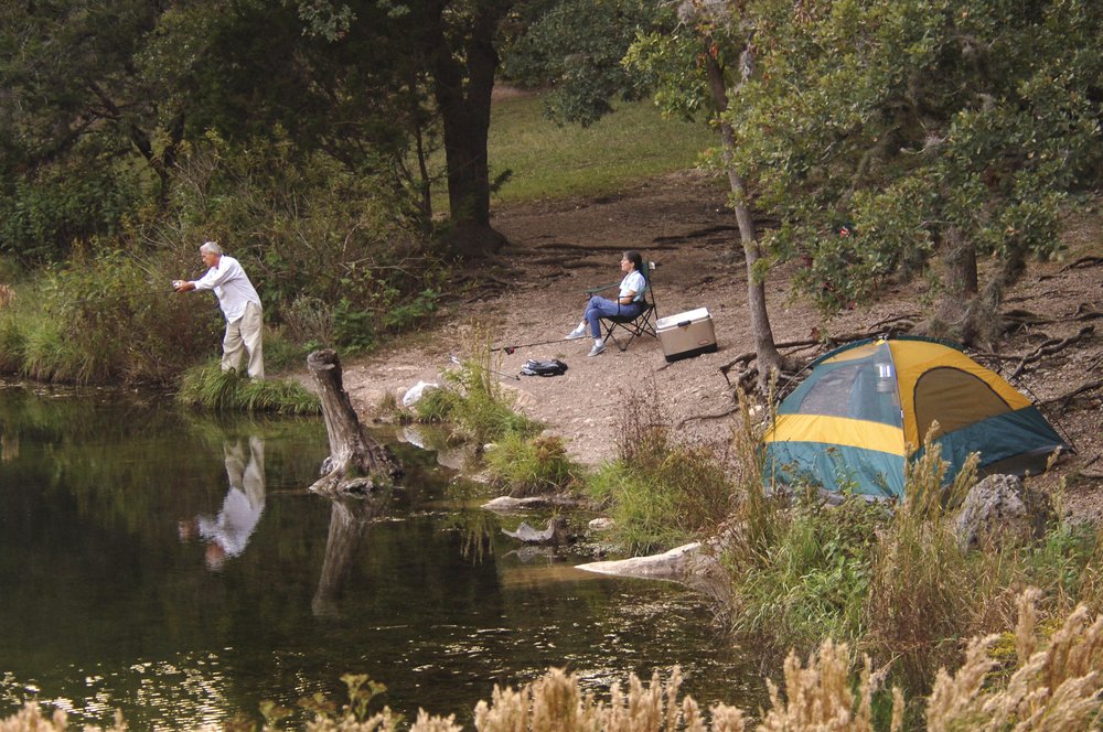 An overhead view of a tent and and a person in a camping chair.