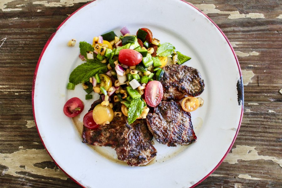 Grilled hog backstrap on a white plate.