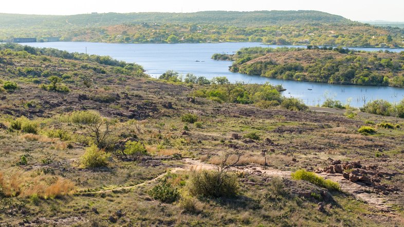 A view of a trail with an overview of a lake.