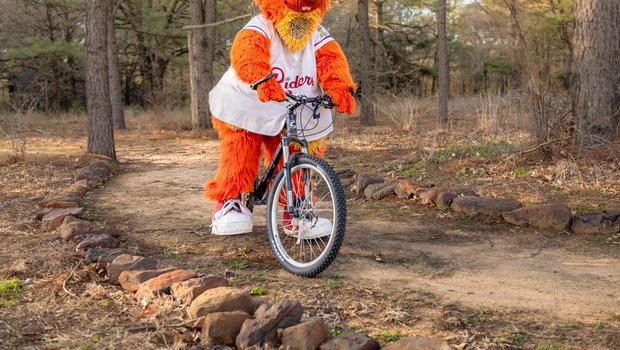 Frisco RoughRiders mascot Deuce biking at Ray Roberts.