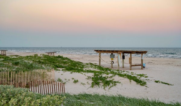 Beach shelter with view of ocean and sunrise.