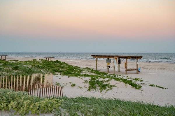 Beach shelter with view of ocean and sunrise.