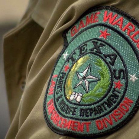 Game warden patch displayed on uniform arm.