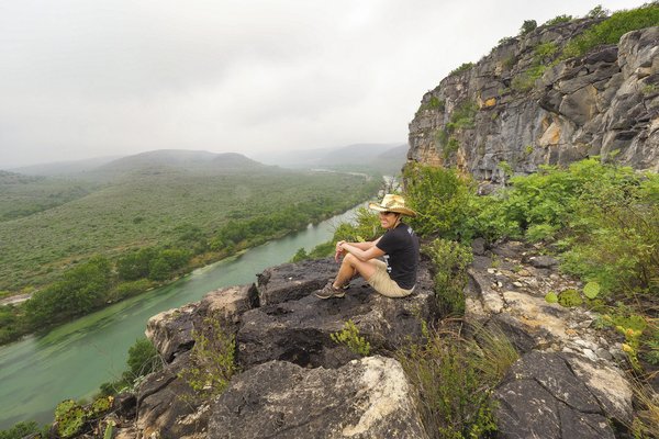 Pam LeBlanc sits on a rock overlooking the Devils River