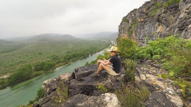 Pam LeBlanc sits on a rock overlooking the Devils River