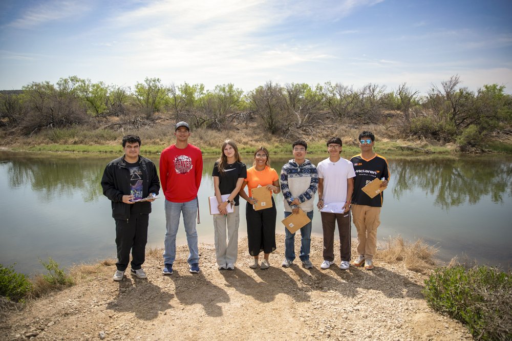 Group shot of volunteers on the banks of Pecos River