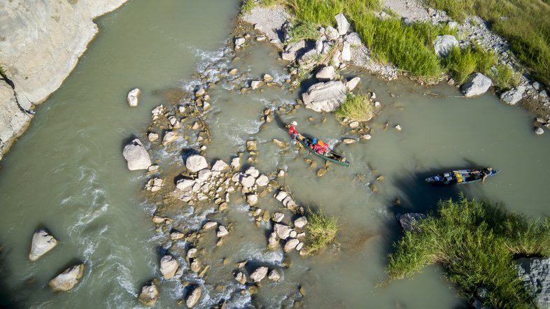 Bird's eye view of kayaker navigating boulders and small rapids on the lower canyons of Rio Grande River