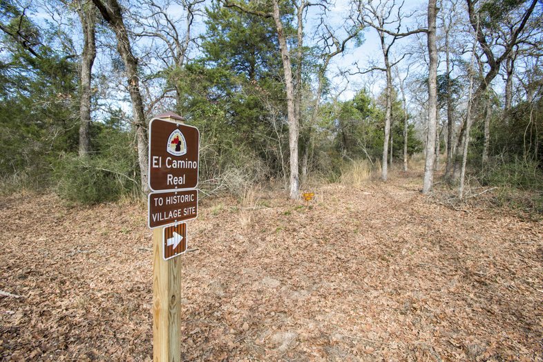 Sign for El Camino Real Trail on new trail through the woods in Milam County
