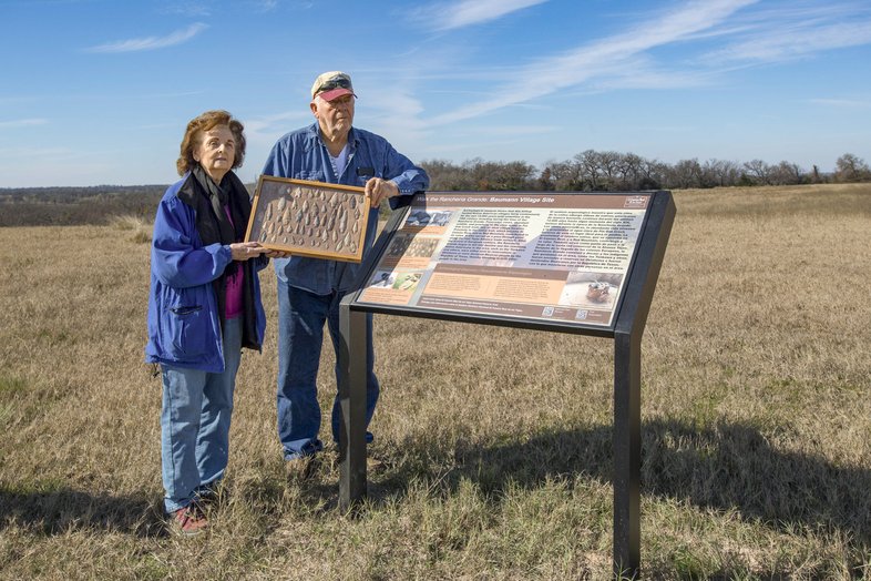 Two property owners show their many projectiles that they found while standing next to sign on El Camino Real trail