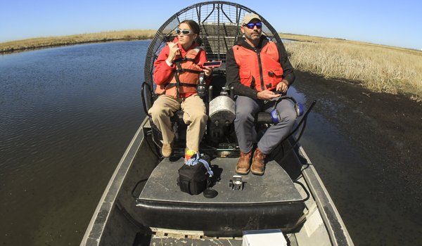 Two people on an airboat.
