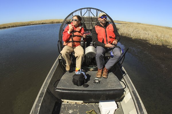 Two people on an airboat.