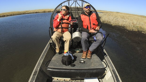 Two people on an airboat.
