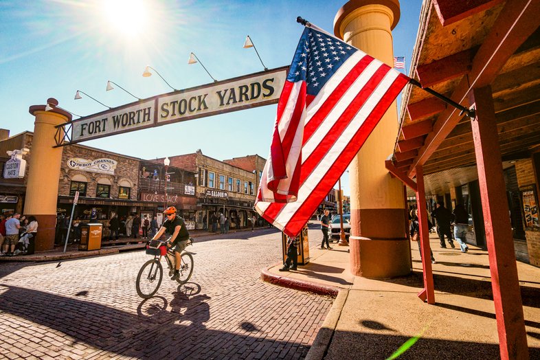 A person riding a bike around the Fort Worth Stock Yards.