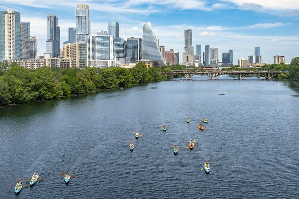 Multiple kayakers on a lake in the city.