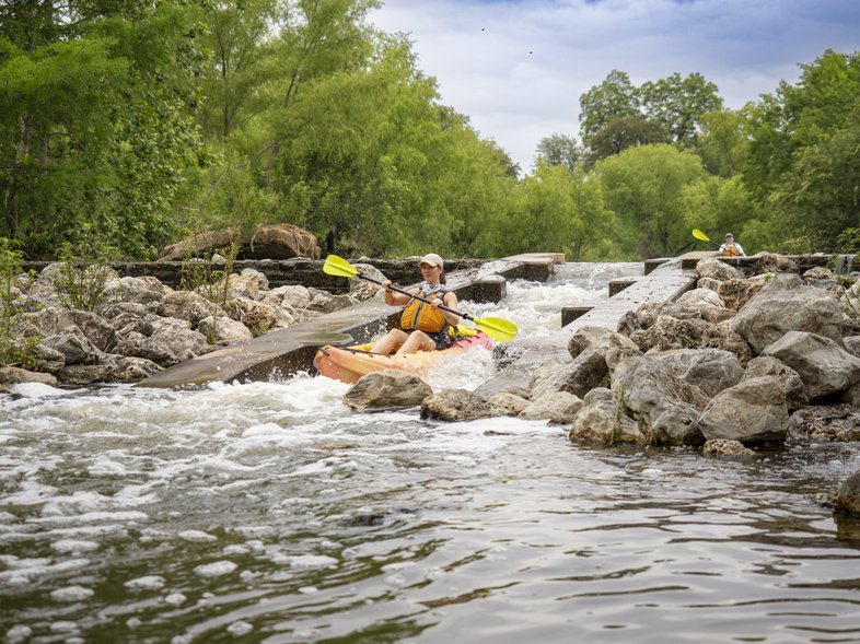 A person kayaking through rapids.
