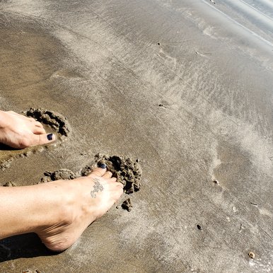 Toes dig into sand along the shore at Sea Rim state park