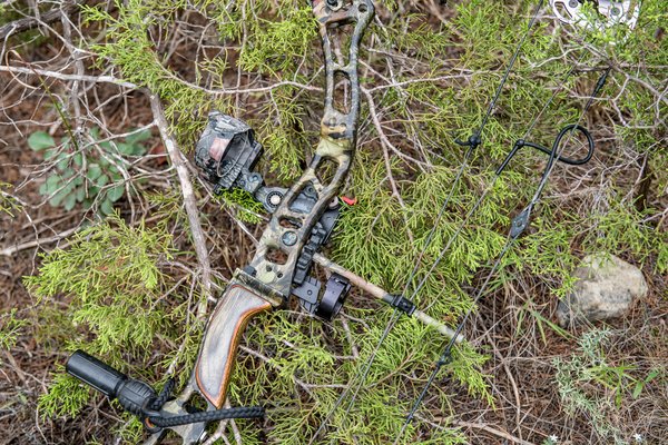 A compound bow rests on the ground