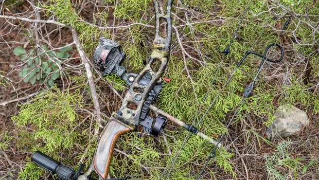 A compound bow rests on the ground