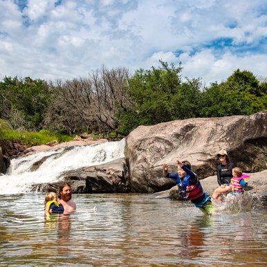 Swimmers splash around at the Devil's Waterhole at Inks Lake State Park