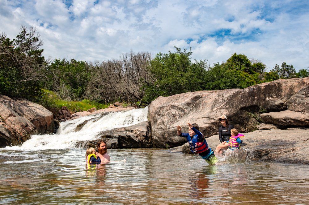 Swimmers splash around at the Devil's Waterhole at Inks Lake State Park