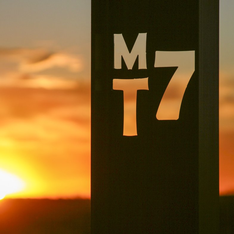 Sunlight shines through the cutout letters spelling out MT7 at the MT7 ranch