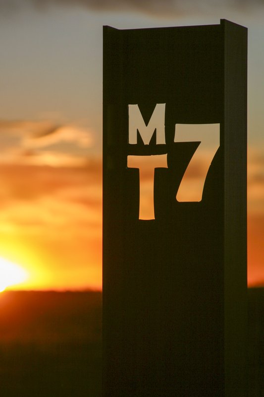 Sunlight shines through the cutout letters spelling out MT7 at the MT7 ranch