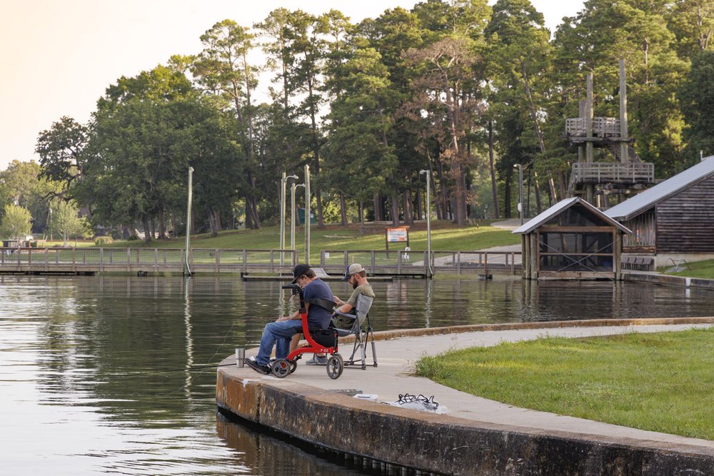 Two anglers sit fishing from the trail bordering Lake Livingston at Lake Livingston state park