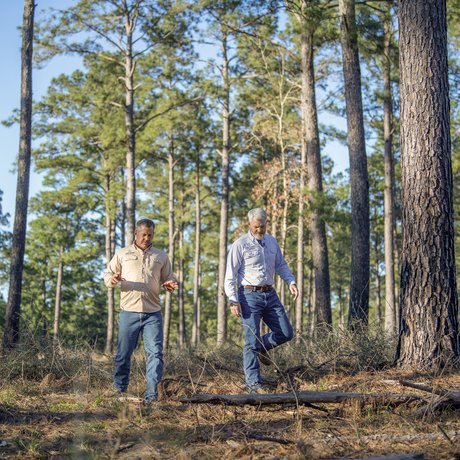 Two men walk through the forest at Boggy Slough Conservation Area