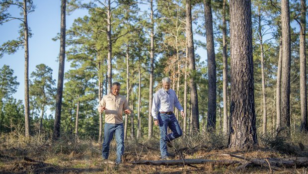 Two men walk through the forest at Boggy Slough Conservation Area