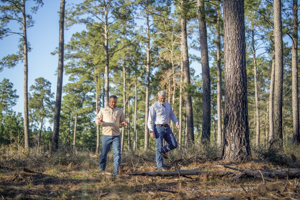 Two men walk through the forest at Boggy Slough Conservation Area