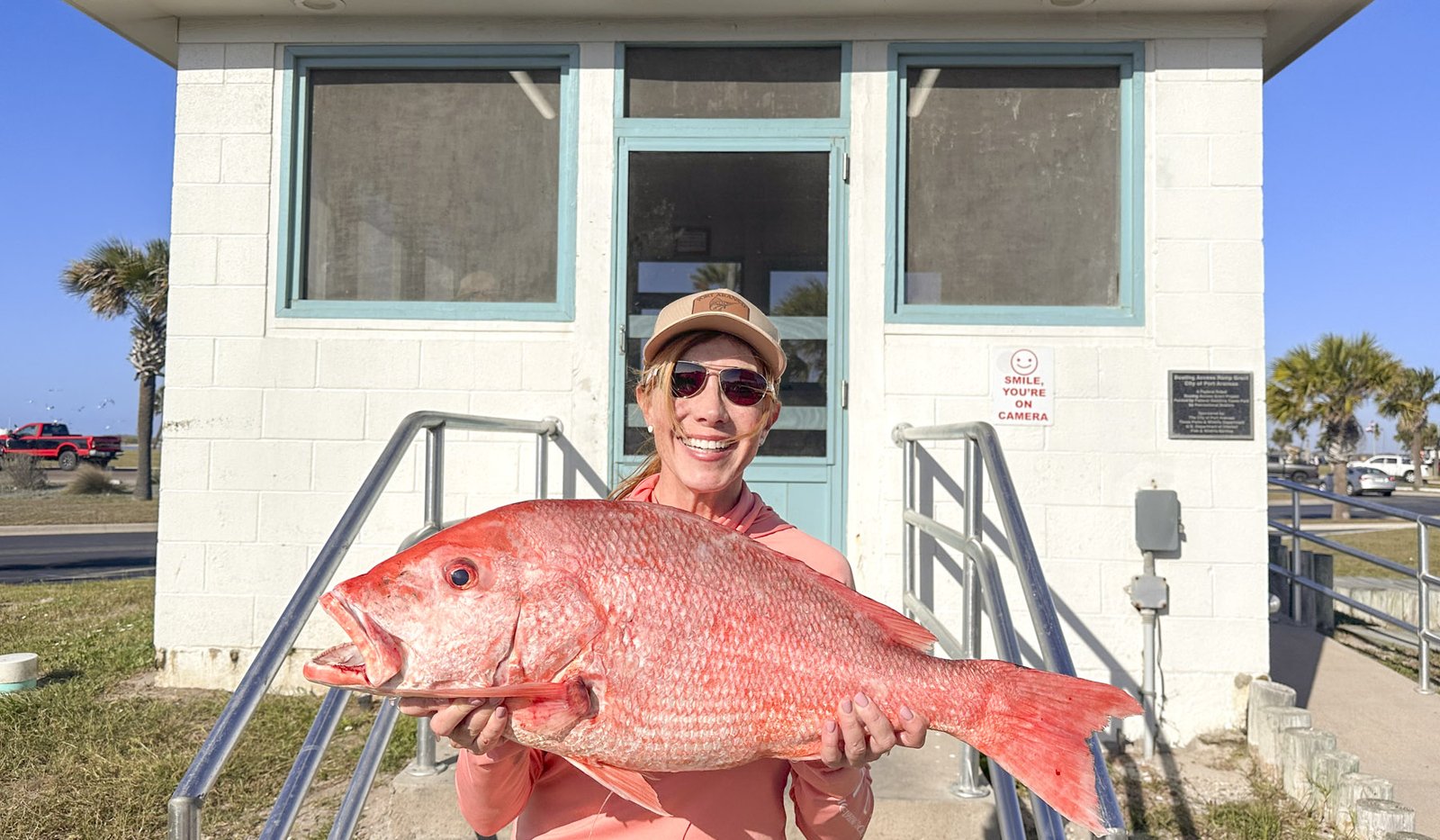 A person holding a large red snapper.
