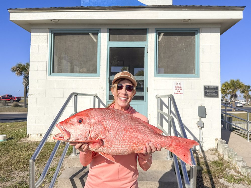 A person holding a large red snapper.