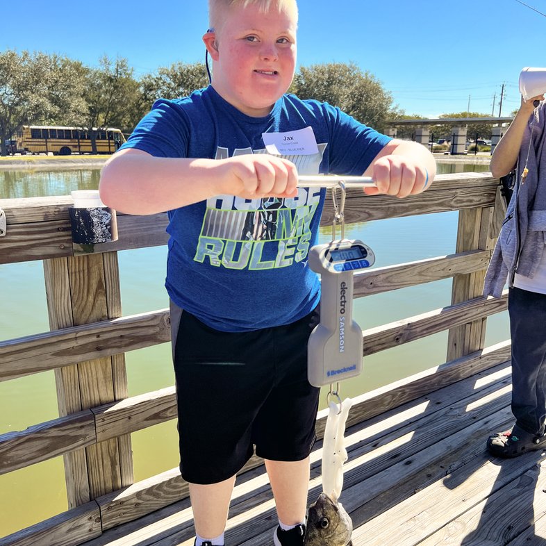 A child weighs a fish he caught at the Special Olympics fishing tournament